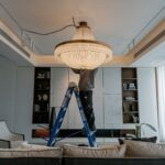 osoba zakładająca żyrandol